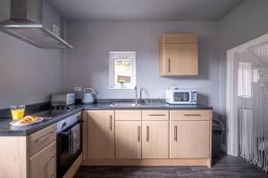 a kitchen with a sink and a microwave at Stunning Home Ideal for Business - Free Parking in Birstall