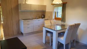 een keuken met een tafel, stoelen en een spoelbak bij Hiška ob gozdu in Polzela +3 foto's