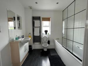 a bathroom with a sink and a toilet and a tub at KENT, DARTFORD STATION APARTMENTs in Dartford