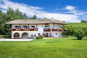 une grande maison blanche avec une pelouse verte dans l'établissement Bonichhof, à Laion