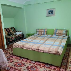 a bedroom with a green bed and a couch at Apartament 3 camere strada Bailor Baltatesti in Bălţăteşti