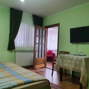 a room with a bed and a table and a television at Apartament 3 camere strada Bailor Baltatesti in Bălţăteşti
