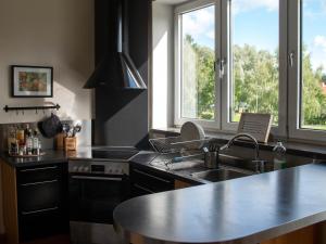 a kitchen with a sink and a stove and windows at Vassbo Logi & Event in Falun