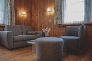 ein Wohnzimmer mit einem Sofa und 2 Stühlen in der Unterkunft Hotel Garni Sonnenhalde in Arosa