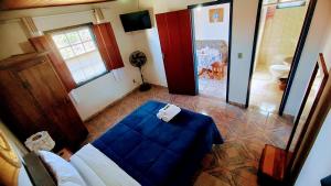 a room with a blue bed and a room with a bathroom at Pouso de Santana in Tiradentes