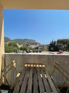 a bench on a balcony with a view of a parking lot at Panisse - Parking - Clim - Wifi in Cassis