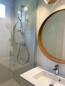 a bathroom with a shower with a sink and a mirror at Panisse - Parking - Clim - Wifi in Cassis