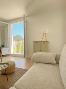 Una sala de estar con un sofá y una ventana grande. en Panisse - Parking - Clim - Wifi, en Cassis