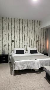 a bedroom with a bed and a wall with trees at Rincón Extremeño in Plasencia