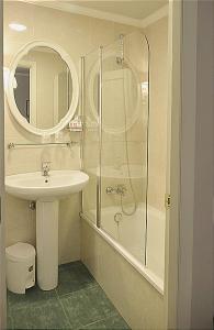 a bathroom with a shower and a sink and a mirror at Hotel Tres Carabelas in Baiona