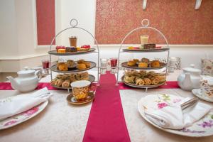 uma mesa coberta com pratos de pastelaria e sobremesas em Dann Carlton Quito em Quito