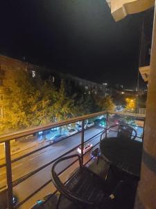 einen Stuhl auf einem Balkon in der Nacht mit einer Straße in der Unterkunft Best Apartment In The City Center in Yerevan