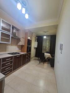 eine Küche mit Holzschränken und ein Wohnzimmer in der Unterkunft Best Apartment In The City Center in Yerevan