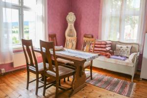 a dining room with a table and chairs and a couch at Lakeside Guesthouse in Ramvik