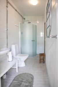 biała łazienka z toaletą i umywalką w obiekcie Lakeside Guesthouse w mieście Ramvik