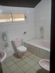 a bathroom with a toilet and a tub and a sink at Grace and favour guest house in Douala