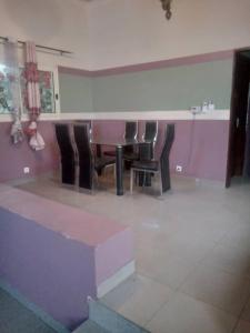 a dining room with a table and chairs in a room at Grace and favour guest house in Douala