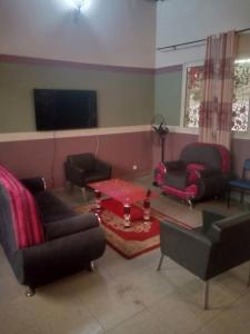 ein Wohnzimmer mit Sofas und einem Tisch in der Unterkunft Grace and favour guest house in Douala