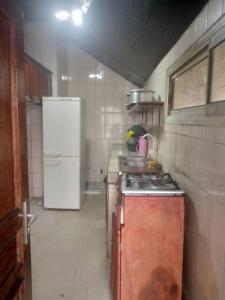 a kitchen with a refrigerator and a stove in it at Grace and favour guest house in Douala