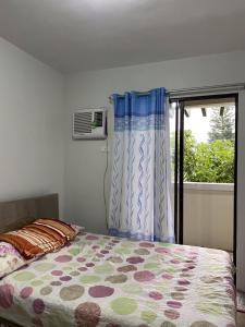 a bedroom with a bed and a window at Alitheia Condo @ Pine Suites Tagaytay in Tagaytay