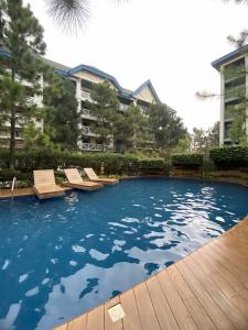 a swimming pool with lounge chairs in a building at Alitheia Condo @ Pine Suites Tagaytay in Tagaytay