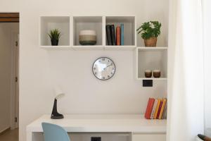 a white desk with a clock and books at Tusa Bay in Castel di Tusa