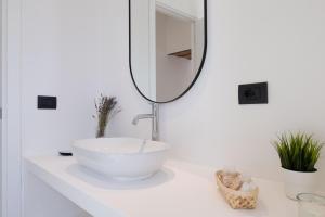 a bathroom with a white sink and a mirror at Tusa Bay in Castel di Tusa