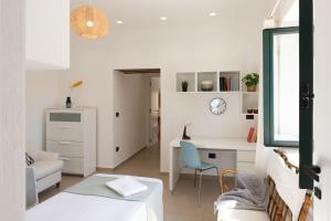 a white living room with a desk and a chair at Tusa Bay in Castel di Tusa