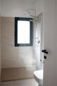 a bathroom with a shower and a toilet and a window at Tusa Bay in Castel di Tusa