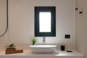 a bathroom with a white sink and a window at Tusa Bay in Castel di Tusa