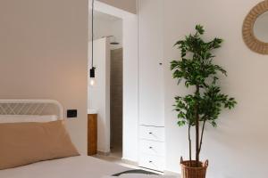 a bedroom with a bed and a potted plant at Tusa Bay in Castel di Tusa