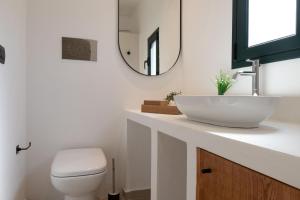 a bathroom with a sink and a toilet and a mirror at Tusa Bay in Castel di Tusa