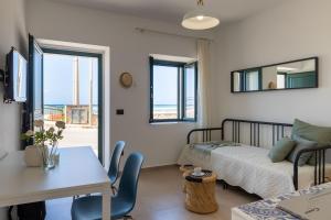 a bedroom with a bed and a table and chairs at Tusa Bay in Castel di Tusa