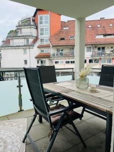 uma mesa de madeira e cadeiras numa varanda em Rosengarten Apartments in Tettnang em Tettnang