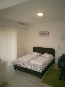 1 dormitorio con cama y alfombra verde en Moderný Apartmán v Podhájskej, en Podhájska