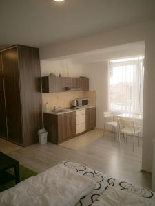 cocina y comedor con mesa, cocina y habitación en Moderný Apartmán v Podhájskej, en Podhájska