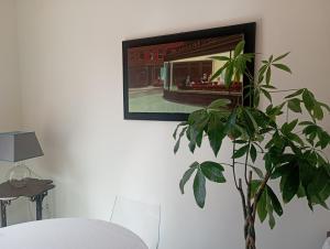 uma imagem pendurada numa parede ao lado de uma planta em Le Petit Relais em Viterbo