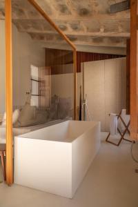 eine weiße Badewanne in einem Zimmer mit einem Bett in der Unterkunft Can Moio Turismo de Interior in Montuïri