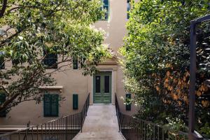a house with a green door and trees at Apartment Wave in Rijeka
