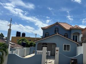 uma casa azul com uma cerca branca em frente em Oak Villa Montego Bay 2 em Montego Bay