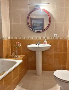 y baño con lavabo, espejo y bañera. en Encantador piso en Villafranca de Córdoba, en Villafranca de Córdoba