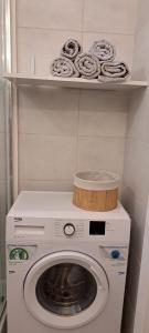 a washer and dryer in a kitchen with a shelf at Apartament w Gdańsku 1 km od plaży in Gdańsk