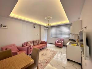 ein Wohnzimmer mit rosa Möbeln und eine Küche in der Unterkunft Mira Suite Apart in Trabzon