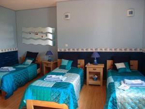 Cette chambre comprend 2 lits avec des couettes bleues. dans l'établissement Guestroom Montigny-lès-Vaucouleurs, 1 pièce, 3 personnes - FR-1-585-110, à Houdelaincourt