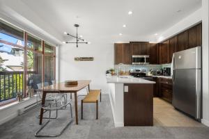 une cuisine avec une table et un réfrigérateur en acier inoxydable dans l'établissement Stoney Creek Northstar by Whistler Premier, à Whistler