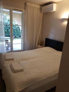 1 dormitorio con cama y ventana grande en Les Jardines d`Artemis (27) en Saint-Tropez