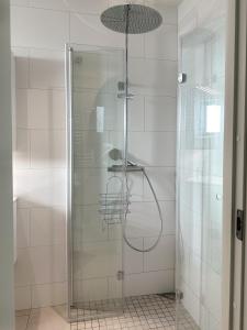 W łazience znajduje się prysznic ze szklanymi drzwiami. w obiekcie Strandviks semesterboende w mieście Halmstad