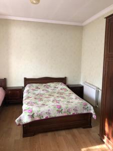 um quarto com uma cama com colcha floral em bakuriani home em Bakuriani