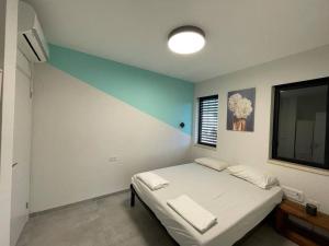 um quarto com uma cama e uma televisão em Roni’s place em Bnei Yehuda
