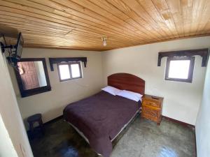 克薩爾特南戈的住宿－Hotel del Ferrocarril，一间卧室设有一张床和木制天花板